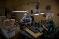 Рабочие готовят шкатулки для росписи в мастерской русской лаковой миниатюры компании в Холуе. James Hill для The New York Times